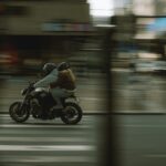 Dynamic city scene with two people riding a motorcycle, motion blur effect.