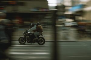 Dynamic city scene with two people riding a motorcycle, motion blur effect.