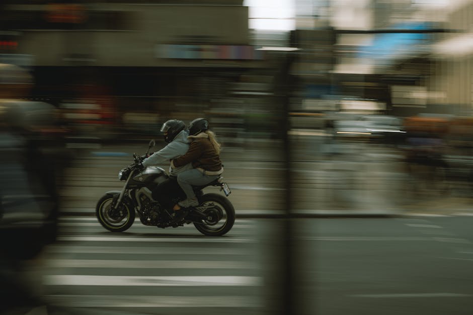 Dynamic city scene with two people riding a motorcycle, motion blur effect.