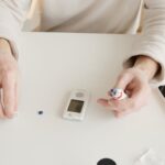 Person using glucometer and kit to check blood glucose levels.