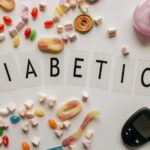 Close-up of candies and diabetes-related items on a white surface, featuring the word 'DIABETICA'.