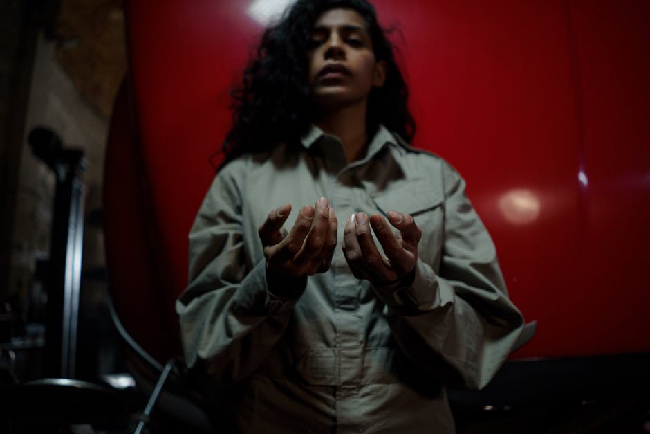 Young female mechanic posing in a workshop, showcasing hands-on skills.