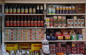 Explore a vintage grocery store shelf filled with bottles, canned goods, and more supplies.