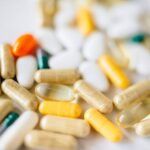 A close-up image of various pills and capsules showcasing diverse colors and types of pharmaceuticals.