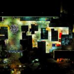 Illuminated aerial view of a vibrant marketplace in Dhaka, highlighting urban nightlife.