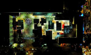 Illuminated aerial view of a vibrant marketplace in Dhaka, highlighting urban nightlife.