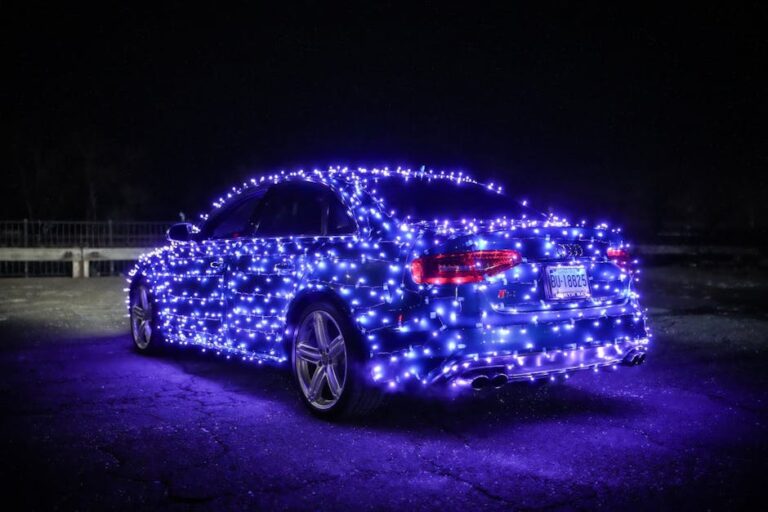 A car adorned with glowing blue lights creating a festive atmosphere in a nighttime setting.