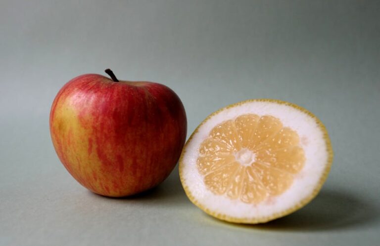 Fresh apple and sliced lemon on a simple background, perfect for food concepts.